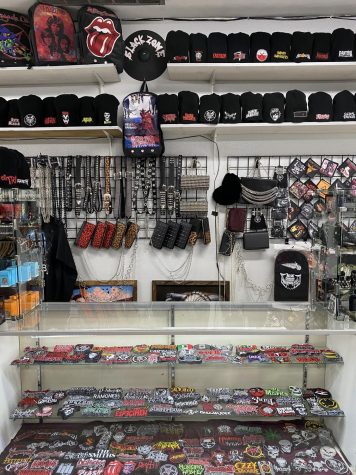 Photo of a glass case displaying patches and beanies. Photography by: Alexis Jacinta.