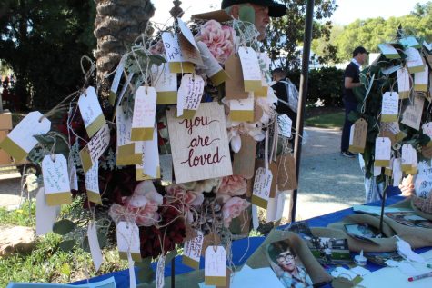 A wreath with handwritten notes dedicated to lost loved ones.