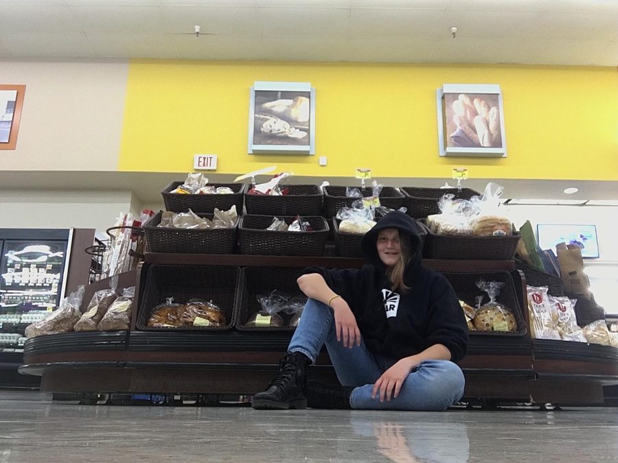 Langley Bradbeer sits in front of a bread stand in Walmart. (Photography by Langley Bradbeer)