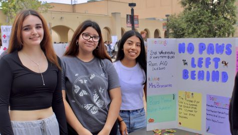 Ariel Meneses, Melissa Castaneda, and Belinda Miguel standing next to their poster at club rush. (Photography by Hayley Durrant)