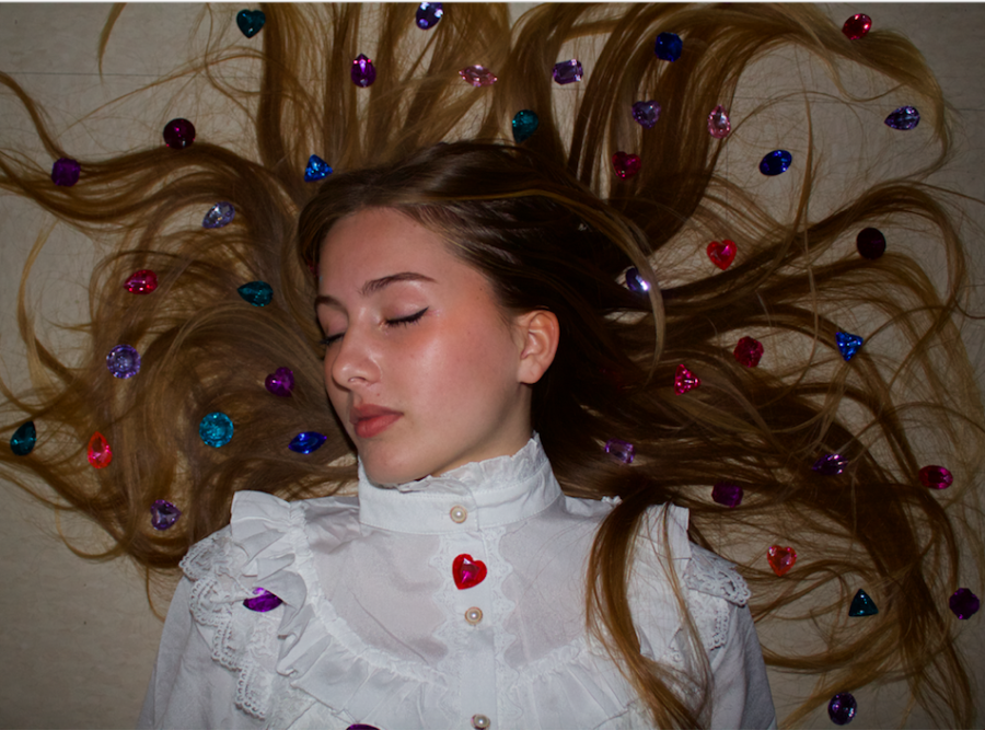 Huntington Beach High School student, Kat Hambrick, lays on the floor in a Victorian-era blouse with gems scattered about.
