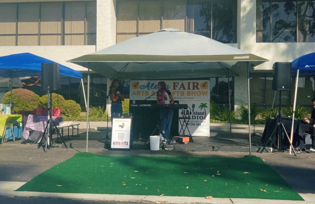 Two young singers singing at the Aloha Fair in support of Maui relief efforts