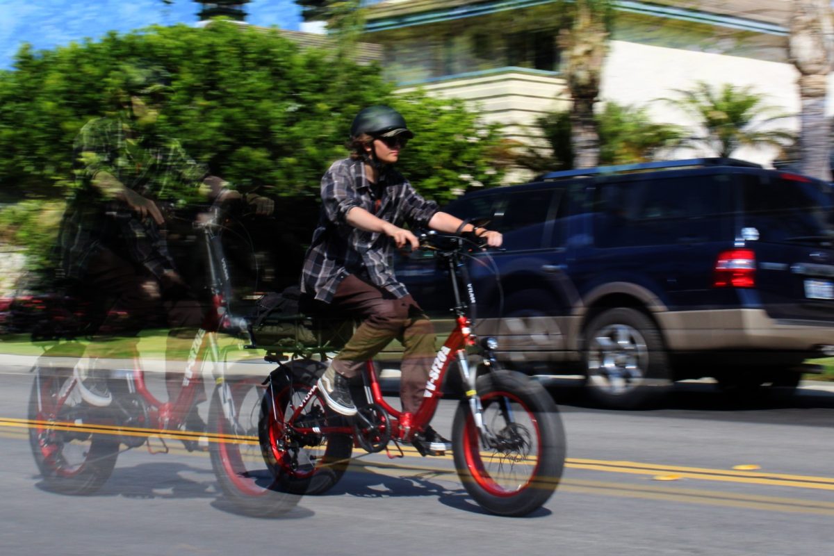 An HBHS student mindfully riding their e-bike a couple streets away from the campus. (Photography by August Berrios)