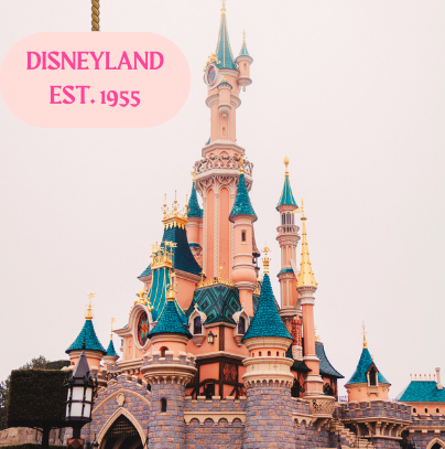 The Sleeping Beauty Castle at Disneyland California with a sign hanging above that reads DISNEYLAND/EST. 1955