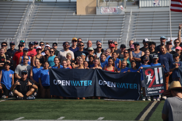 Participants group together holding an OpenWater sign in appreciation for the event