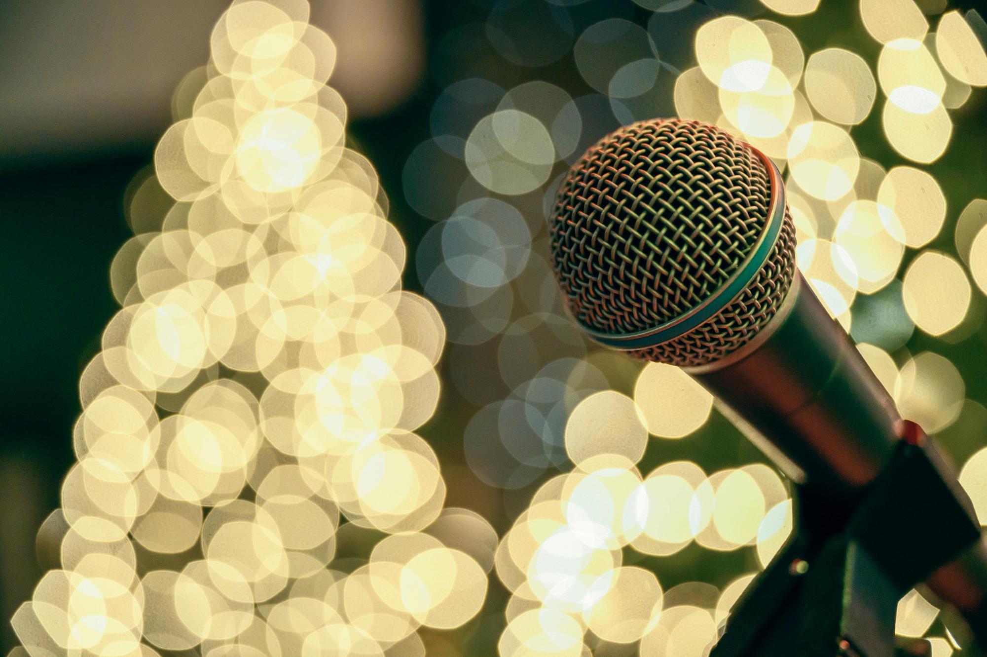 A microphone stands by glowing lights. Photo by Brett Sayles from Pexels. 