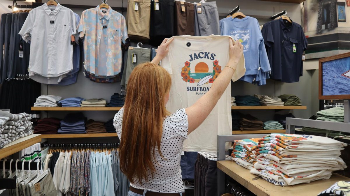 Taylor Spence holding up her product in the Jack's store.