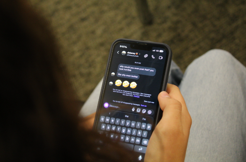 A high school student reading negative messages sent through Instagram.