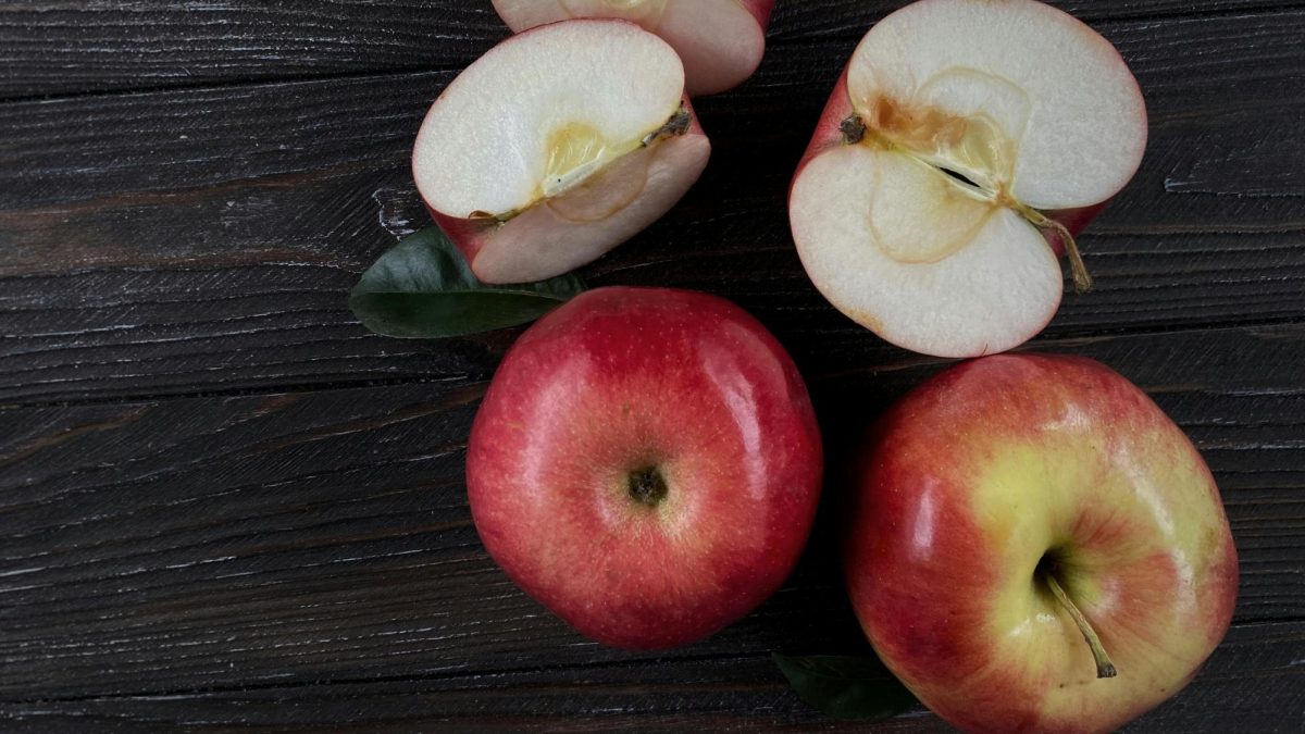 A photo of whole and cut red apples. Photo by Iryna Velychko from Pexels.