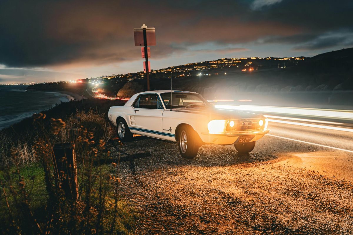 A car pulls over on a dark coastal road. Photo by Mikey White from Pexels.